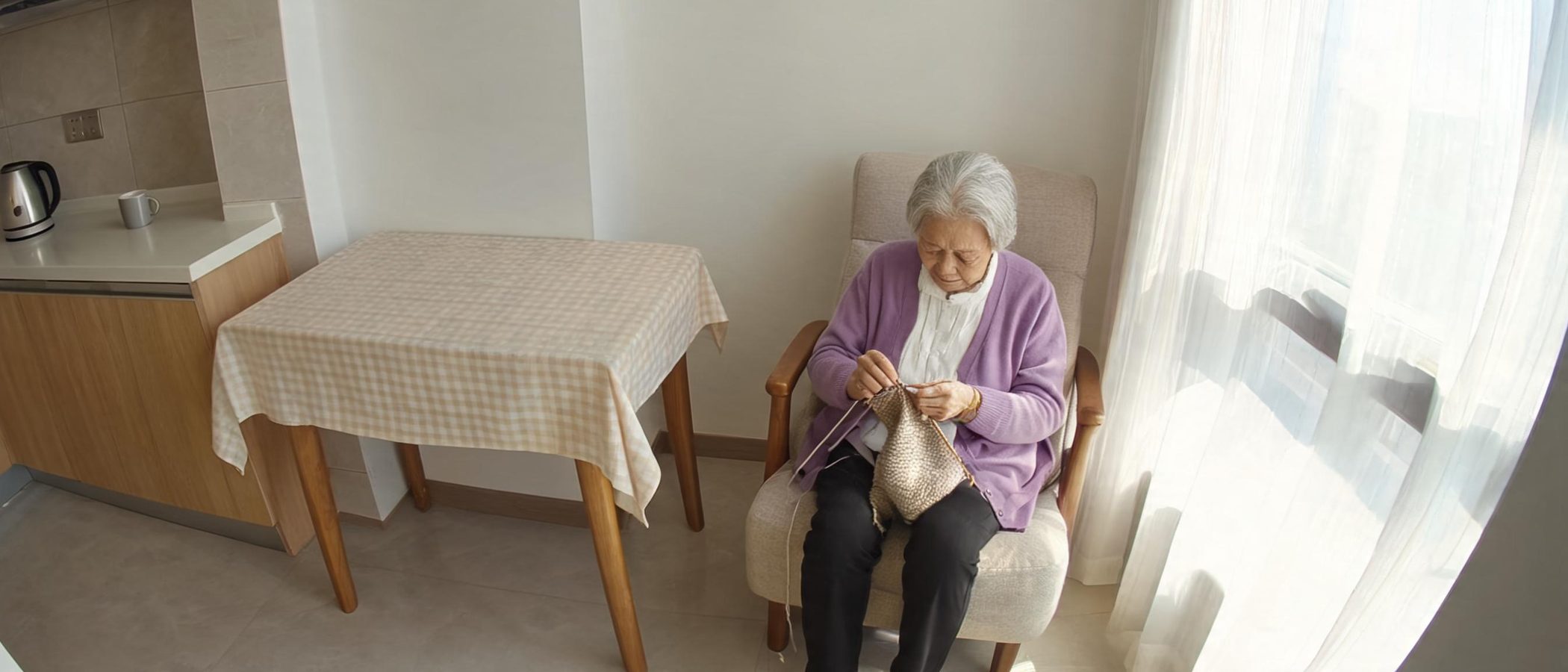 A wide view across an older woman's kitchen and living room