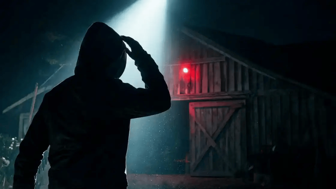 A person caught in the spotlight backs away