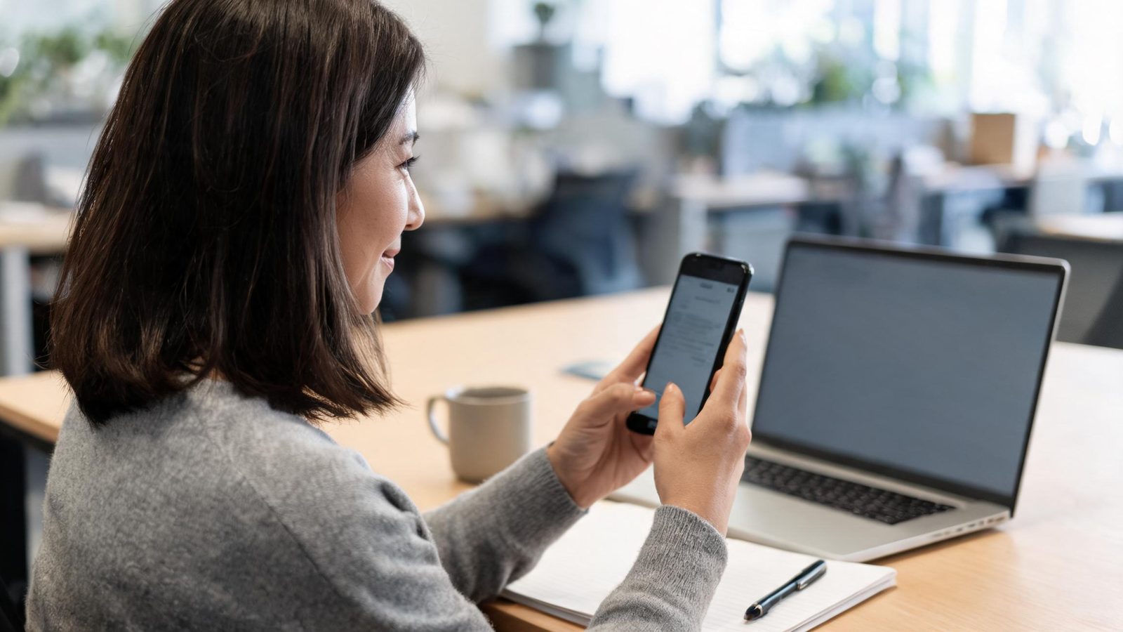 A woman checks the app at her office desk
