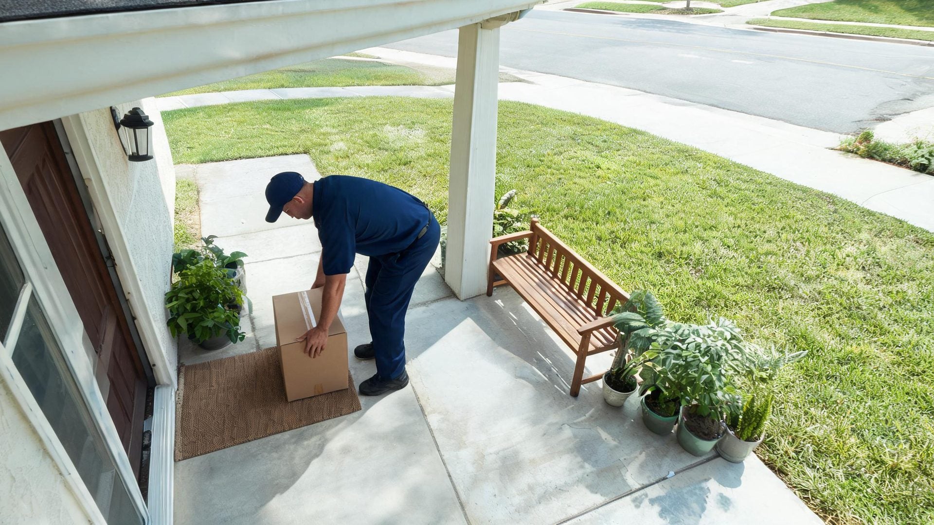 A courier sets a parcel down on the doormat